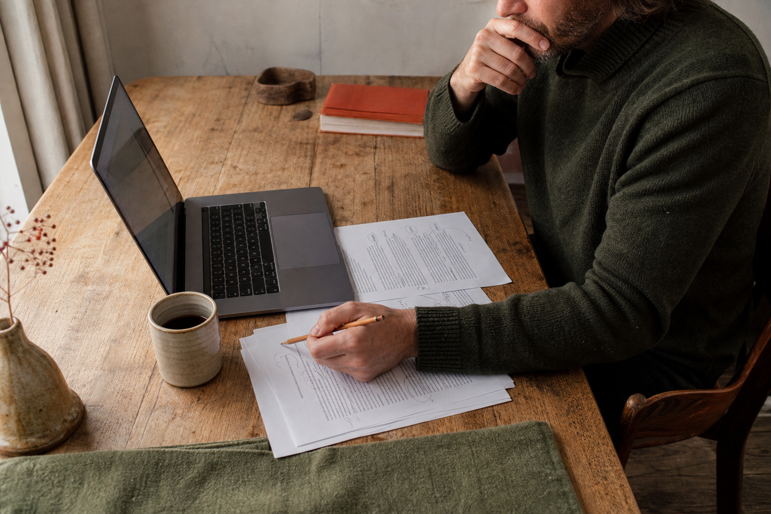 Laptop met een overzichtelijke kennisbank naast geprinte notities en een pen